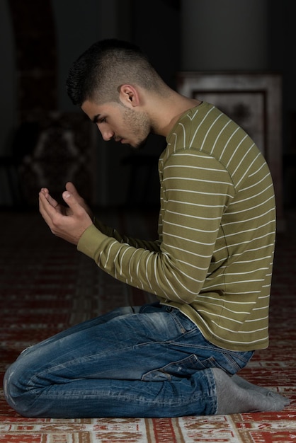 Photo muslim man is praying in the mosque