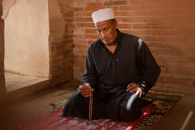 Muslim man is praying at an old mosque in Thailand.