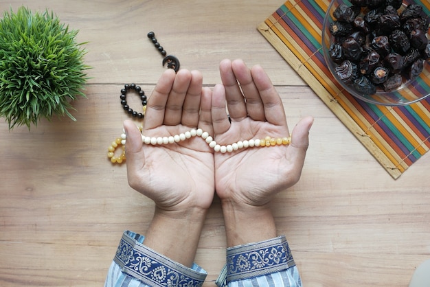 Photo muslim man keep hand in praying gestures during ramadan close up