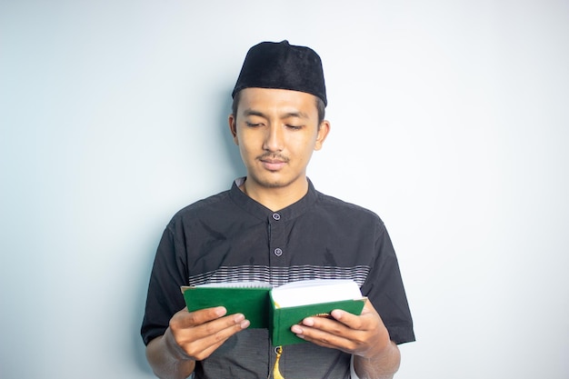 A muslim man reading a holy book.