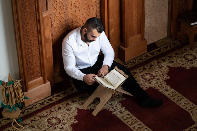 聖なるイスラム教の本コーランを読んでイスラム教徒の男