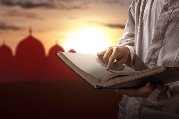 Muslim man reading the Quran on his hands