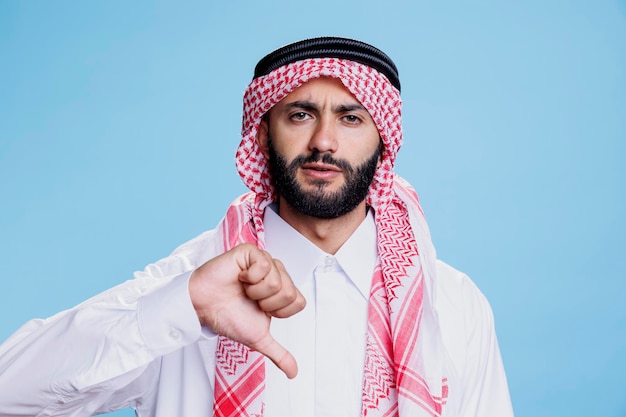 Photo muslim man showing thumb down gesture