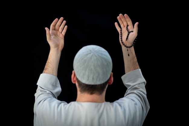 Muslim man standing and praying in the front of Kaaba in Mecca, KSA