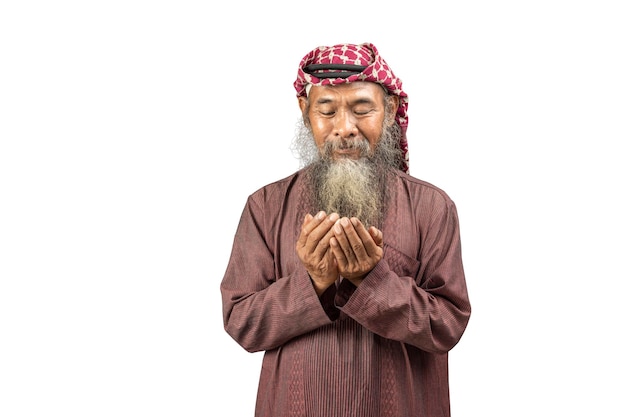 Uomo musulmano con barba che indossa kefiah con agal in preghiera mentre alza le mani