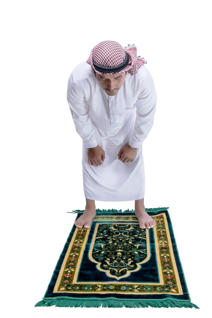 祈りの敷物の上で祈りの位置のサラッにアガルとクーフィーヤを持つイスラム教徒の男