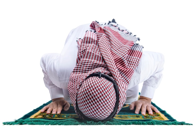 Muslim man with keffiyeh with agal in praying position salat on the prayer rug