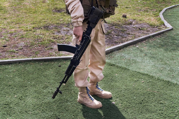 写真 ライフルを持ったイスラム教徒の過激派。草の背景にカラシニコフを保持している軽い軍服の兵士