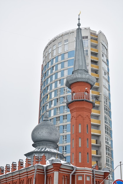 Photo muslim mosque in the background of a skyscraper