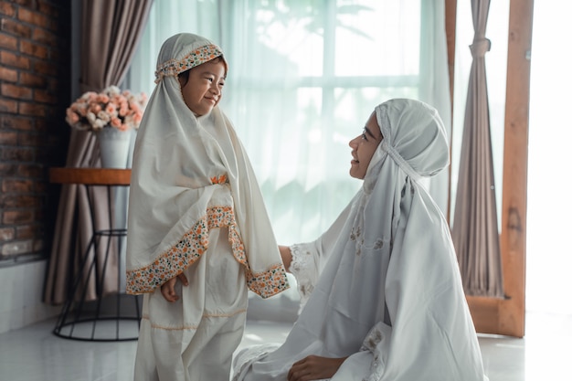 Muslim mother and child with scarf to pray
