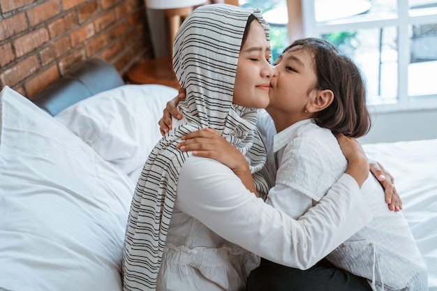 Muslim mother cuddling with her daughter