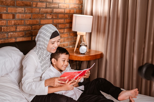 Muslim mother reading a book with her son