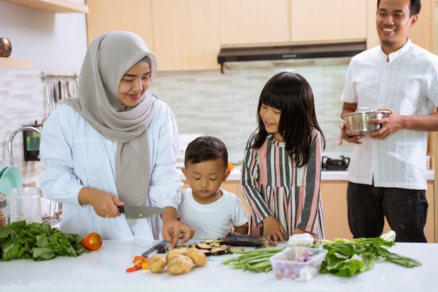 イスラム教徒の親と子供たちは一緒にイフタールディナーの料理を楽しんでいます