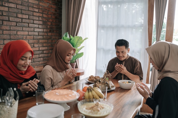 Muslim people praying before having their food