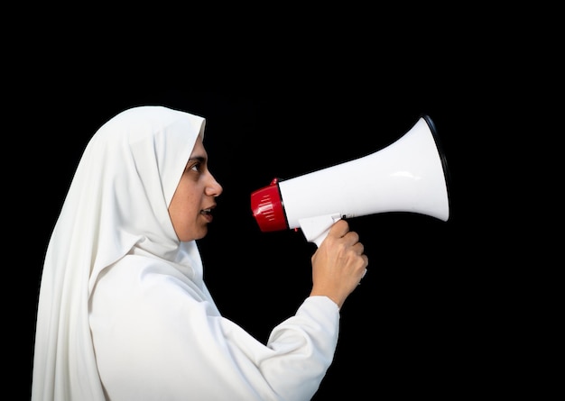 확성기 고품질 사진에 메시지를 말하는 흰색 전통 옷을 입은 이슬람 순례자