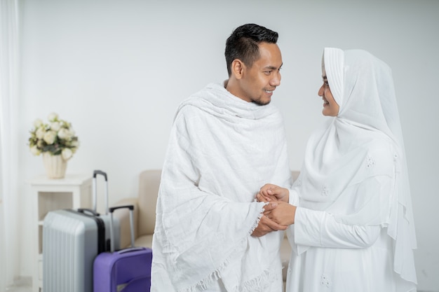 イスラム教徒の巡礼者の妻と夫の白い伝統的な服