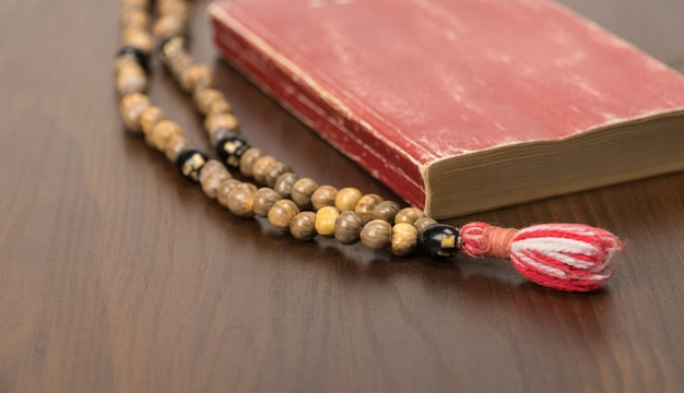 Photo muslim prayer beads and koran isolated on a wooden background. islamic and muslim concepts