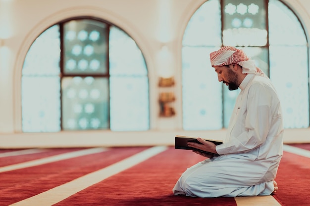 무슬림 성월인 라나잔(Ranazan) 동안 한 무슬림이 현대적인 그랜드 모스크에서 신성한 이슬람 책 쿠라킨(Quraqn)을 읽고 있습니다.