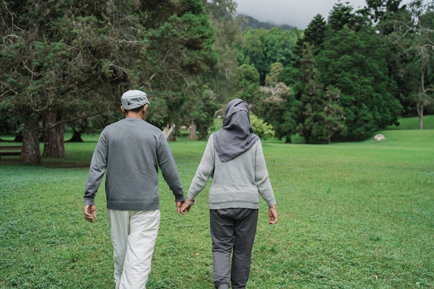 Coppie senior musulmane che camminano insieme nel giardino