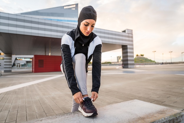 Мусульманская спортивная девушка с подтянутым телом тренируется на улице