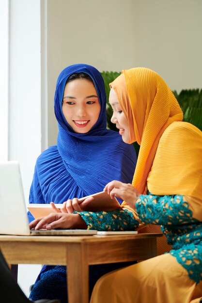 Muslim students doing homework in cafe