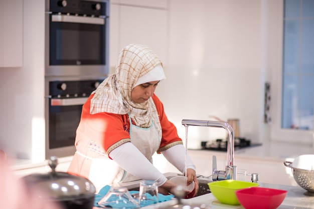 muslim traditional woman cleaning in kitchen