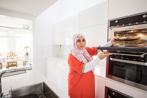 Muslim traditional woman using stove