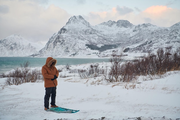 Muslim traveler praying in cold snowy winter day near the car in Scandinavia