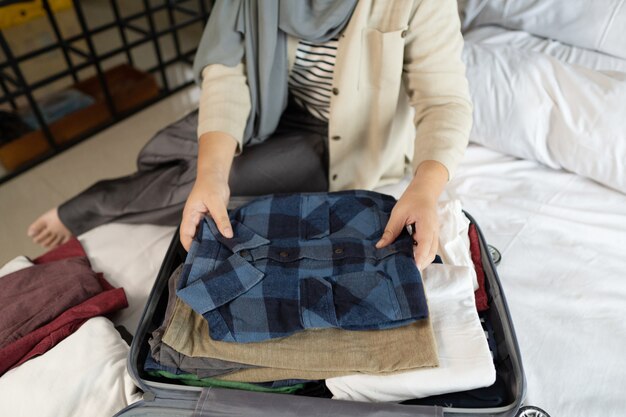 Photo muslim veiled woman packing some clothes