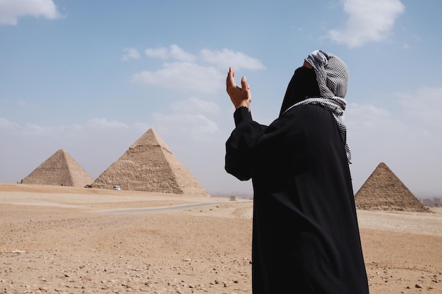 A Muslim with robe clothes praying on the desert