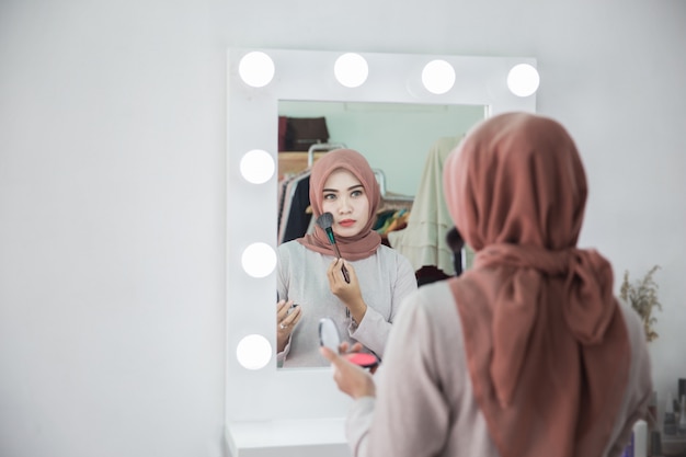 Muslim woman applying makeup