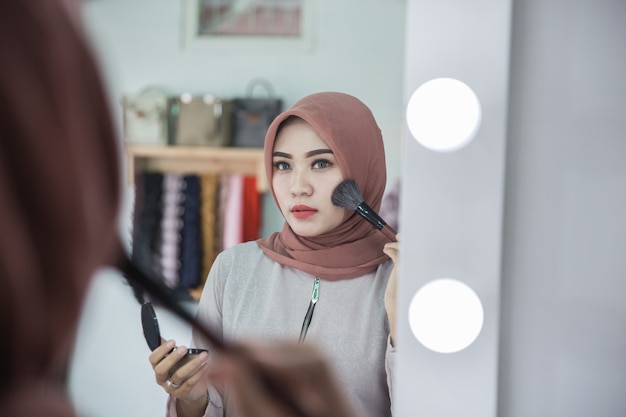 Muslim woman applying makeup