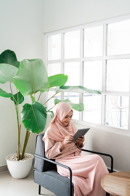 Muslim woman browsing with tablet while relaxing