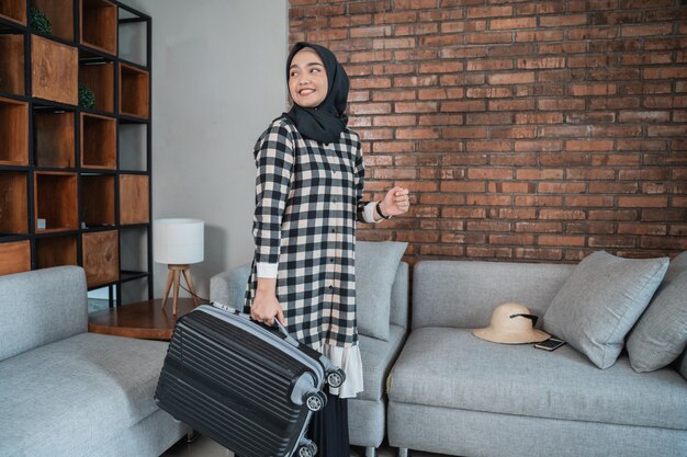 Muslim woman carrying suitcase