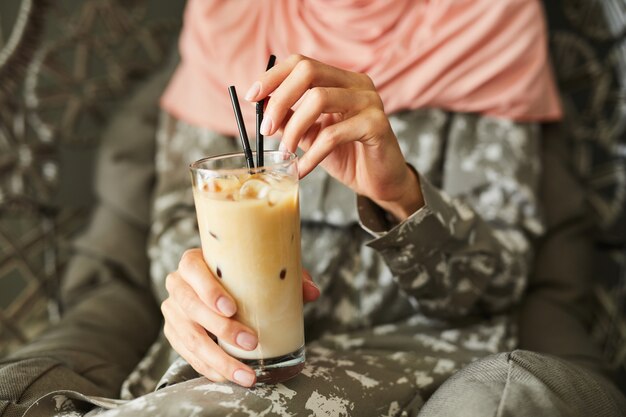 Muslim woman drinking iced coffee