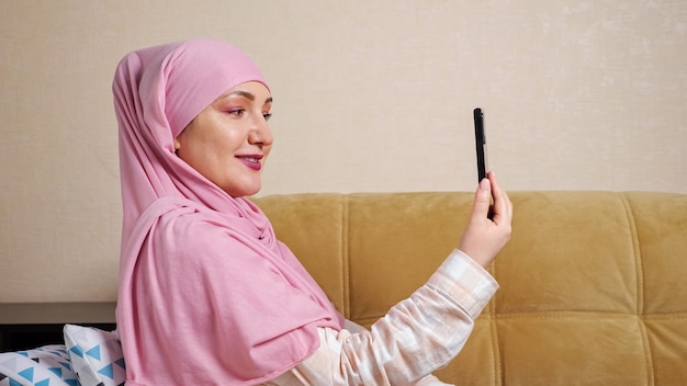Muslim woman in hijab talking by video link.