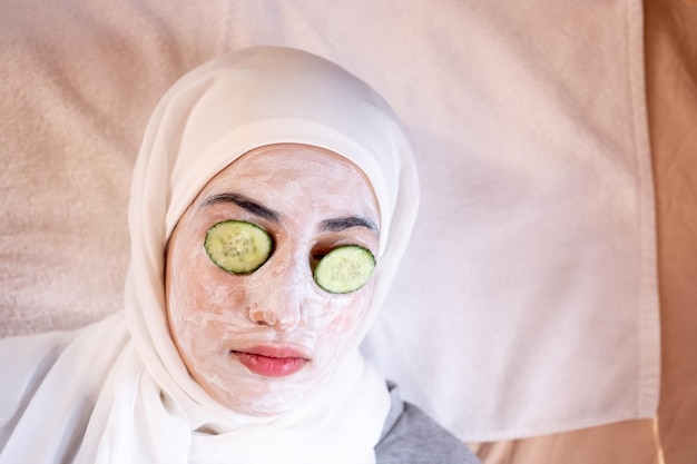 Muslim woman laying down in a spa with facial mask