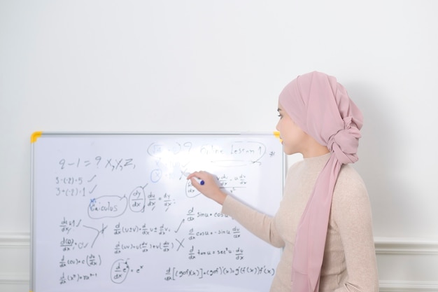 A muslim woman lecturer using laptop for lecturing online via internet. E-learning and telecommunication Concept