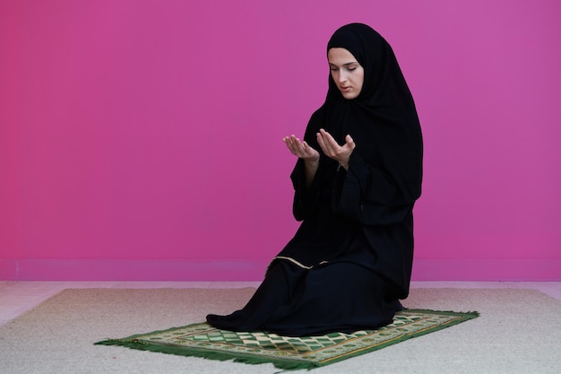 Muslim woman in namaz praying for allah muslim god. muslim\
woman on the carpet praying in traditional middle eastern clothes,\
woman in hijab