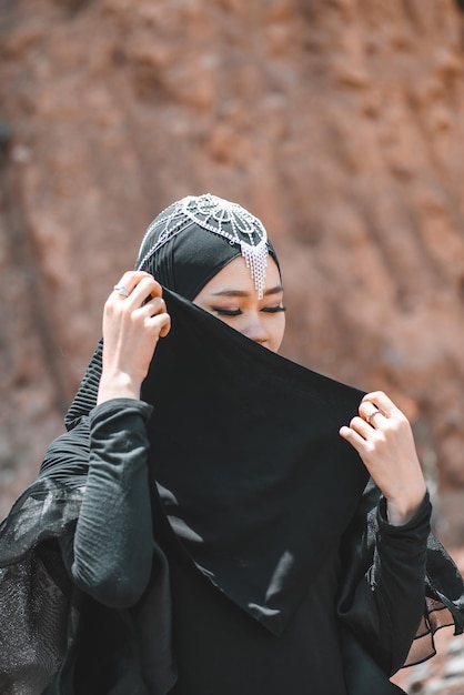 砂漠のクローズ アップでイスラム教徒の女性のポーズ