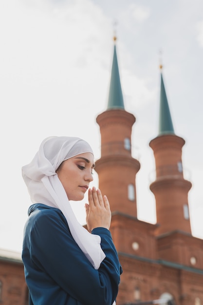 イスラム教徒の女性の祈りは、モスクでアッラーにヒジャーブの断食の祈りを身に着けています