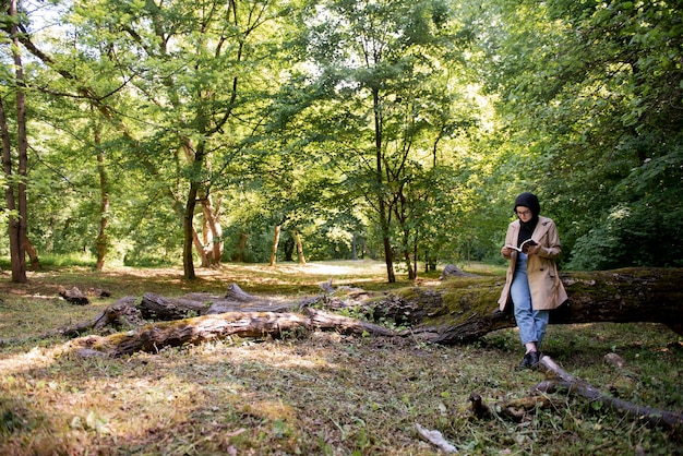 Donna musulmana che legge un libro nel parco durante il suo tempo libero