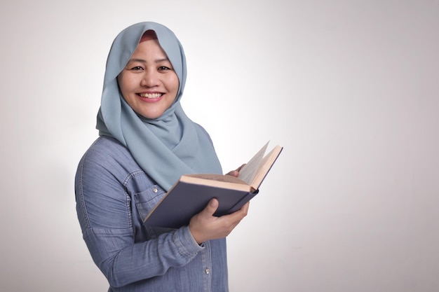 Мусульманка читает книгу и улыбается