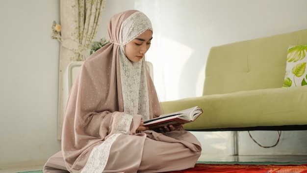 Мусульманка серьезно читает коран дома