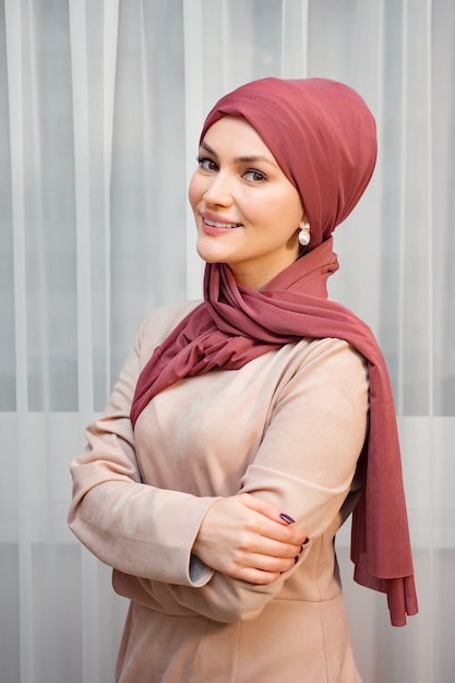 Muslim woman in a red scarf and closed clothes.