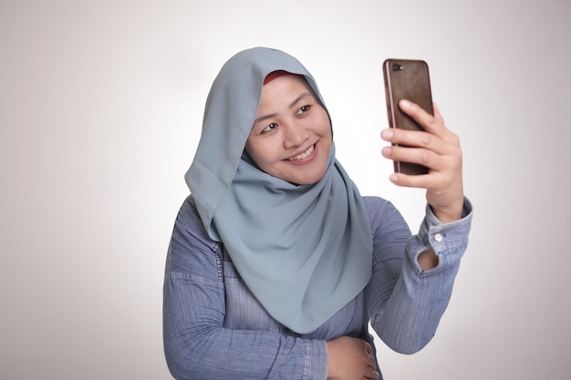 Muslim Woman Smiling and Taking Selfie Picture of Her Self on Phone