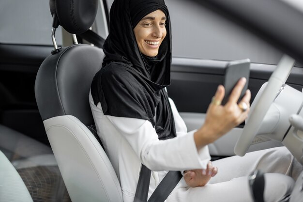 차를 운전하면서 전화통화를 하는 이슬람 여성