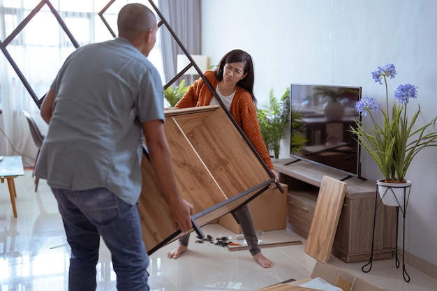 Muslim woman try so hard to lift the new furniture