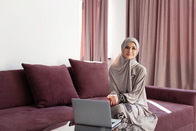 Muslim Woman Using laptop and Phone at home