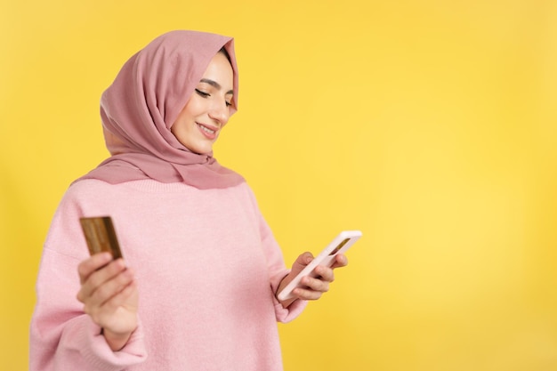 Muslim woman using the mobile and card to shopping online